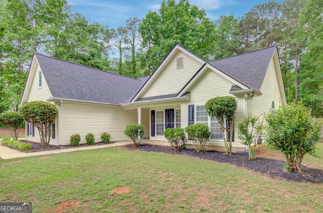 view of front of home with a shingled roof and a front lawn