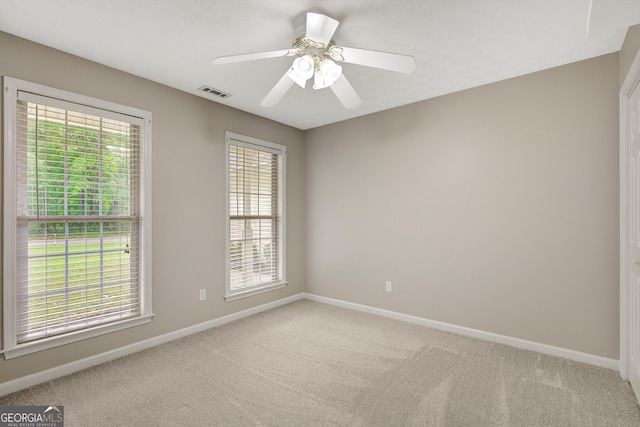 unfurnished room featuring baseboards, visible vents, and light carpet