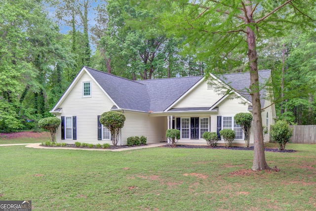 view of front of home featuring fence, a shingled roof, and a front lawn