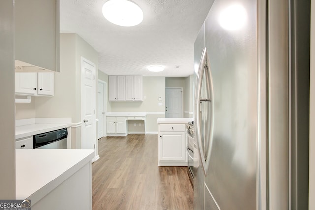 kitchen with white cabinets, light wood-style floors, appliances with stainless steel finishes, and light countertops