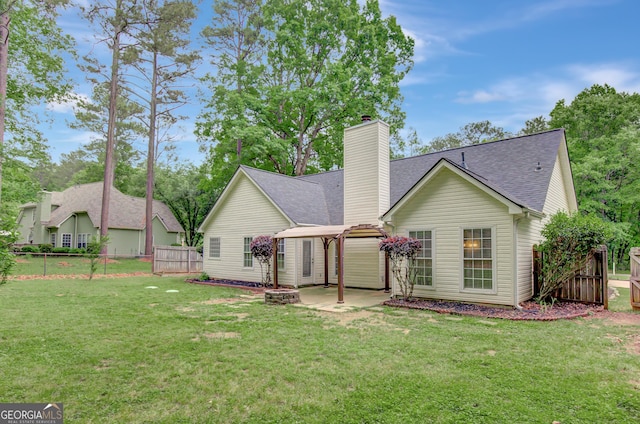 back of house with a chimney, a shingled roof, a patio area, fence, and a fire pit