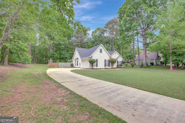 view of front of house with fence, driveway, and a front lawn
