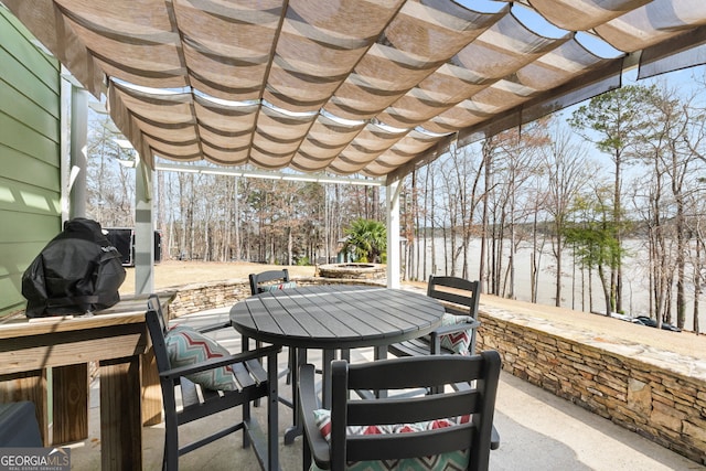 view of patio featuring outdoor dining area, a pergola, and a water view