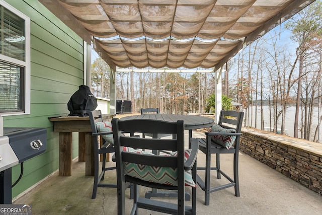 view of patio featuring a water view and outdoor dining area