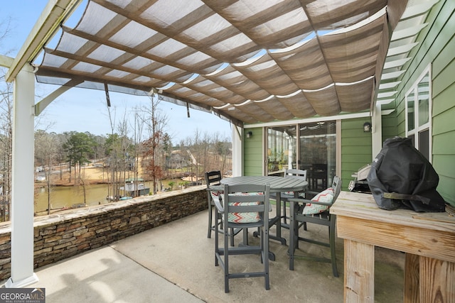 view of patio / terrace featuring a pergola, outdoor dining area, and a water view