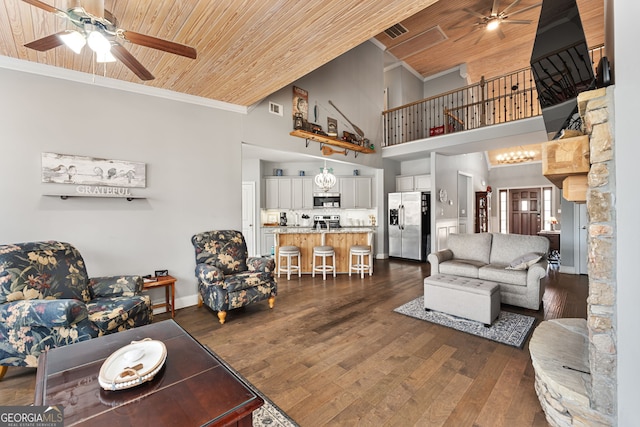 living area featuring a ceiling fan, wooden ceiling, crown molding, a towering ceiling, and baseboards