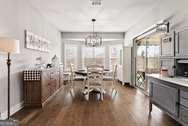 dining area with a chandelier, dark wood finished floors, healthy amount of natural light, and baseboards