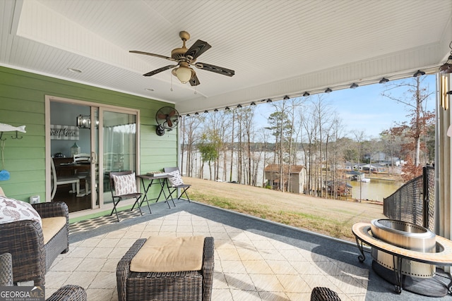 view of patio / terrace featuring ceiling fan and a water view