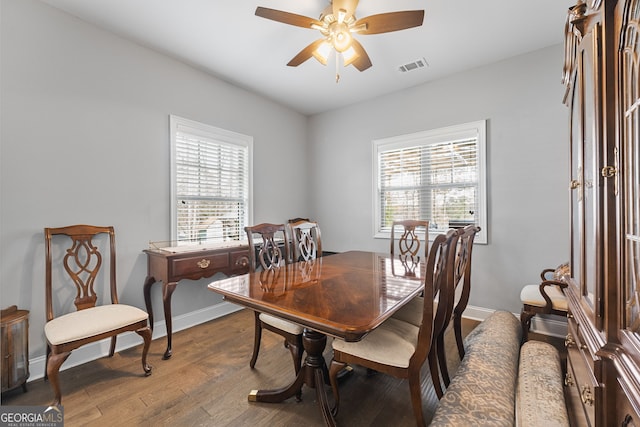 dining room featuring ceiling fan, wood finished floors, and baseboards