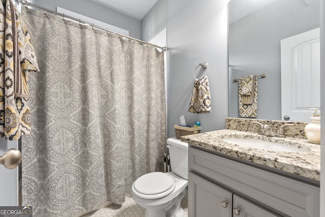 full bathroom featuring toilet, vanity, and tile patterned flooring