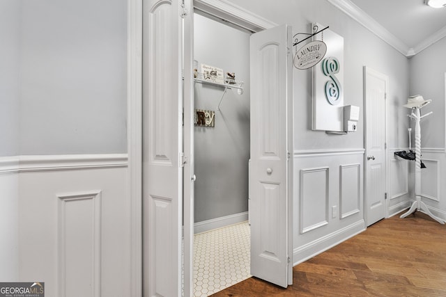 bathroom with ornamental molding, wood finished floors, and wainscoting