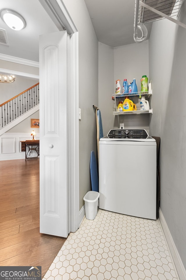 washroom with washer / clothes dryer, crown molding, and baseboards