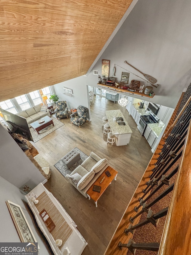 living room with wood finished floors, wooden ceiling, and lofted ceiling