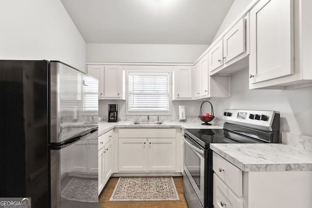 kitchen featuring stainless steel appliances, a sink, light countertops, and white cabinetry
