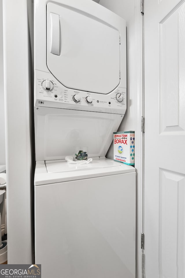 washroom featuring stacked washer and clothes dryer