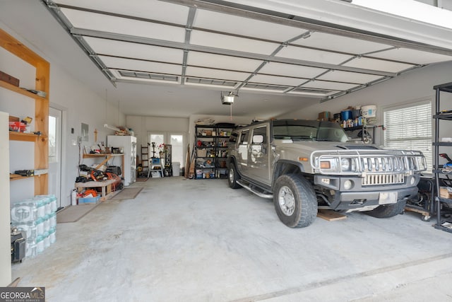 garage with a garage door opener and freestanding refrigerator