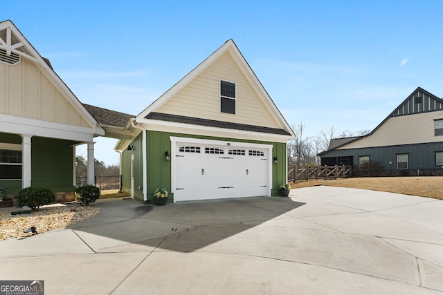 view of home's exterior featuring board and batten siding, driveway, fence, and roof with shingles
