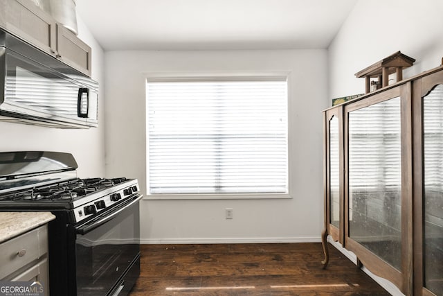 kitchen with black gas range, dark wood-type flooring, gray cabinets, and baseboards