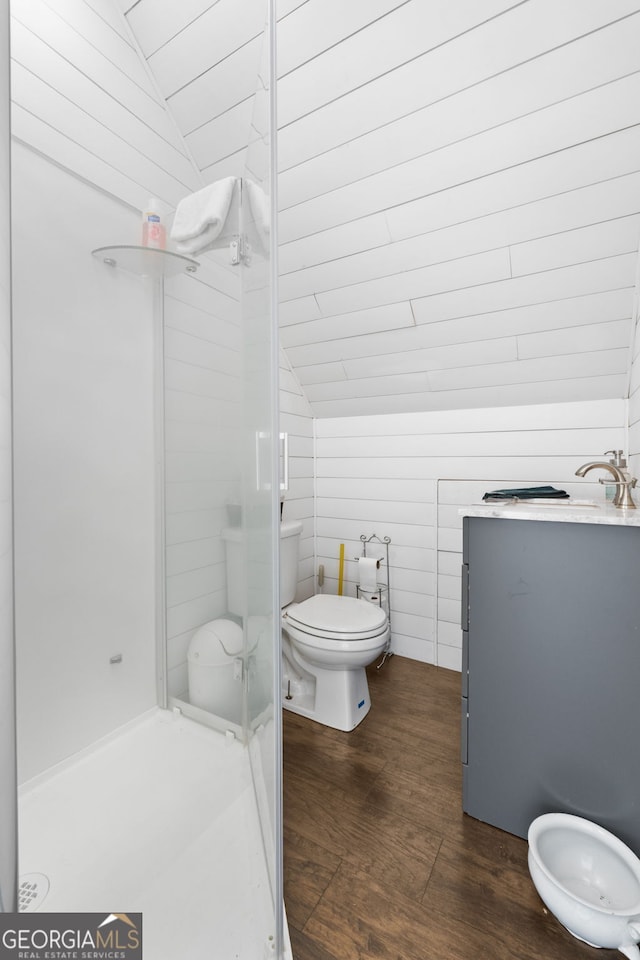 full bathroom with vaulted ceiling, toilet, a shower stall, and wood finished floors
