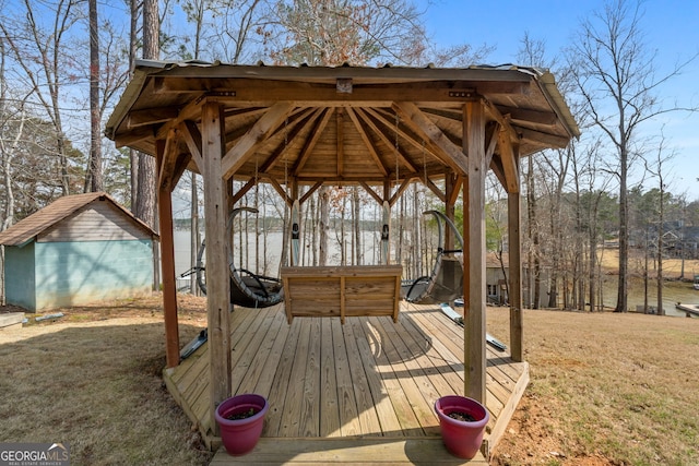 deck with a lawn, an outbuilding, a gazebo, and a storage shed