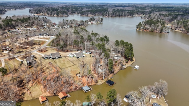 aerial view of property's location featuring a large body of water and a heavily wooded area