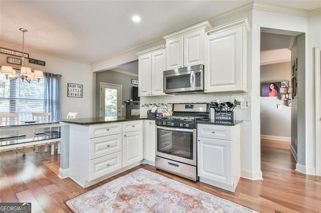37 Wood Duck Pt, Jefferson, GA 30549 - kitchen featuring appliances with stainless steel finishes, a chandelier, a peninsula, ornamental molding, and white cabinets