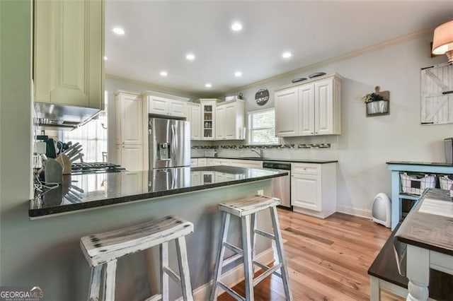 37 Wood Duck Pt, Jefferson, GA 30549 - kitchen featuring stainless steel appliances, crown molding, a peninsula, a breakfast bar area, and white cabinets