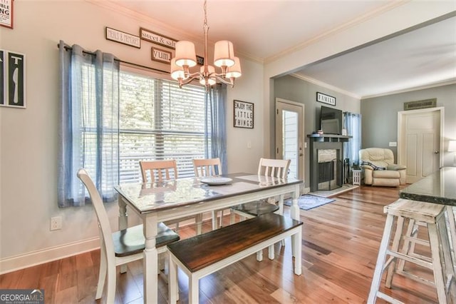 37 Wood Duck Pt, Jefferson, GA 30549 - dining area featuring a chandelier, wood finished floors, crown molding, and a fireplace