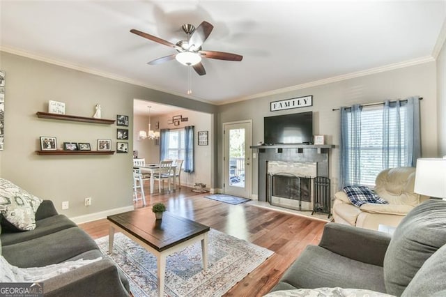 37 Wood Duck Pt, Jefferson, GA 30549 - living room featuring a ceiling fan, a fireplace with flush hearth, wood finished floors, crown molding, and a chandelier
