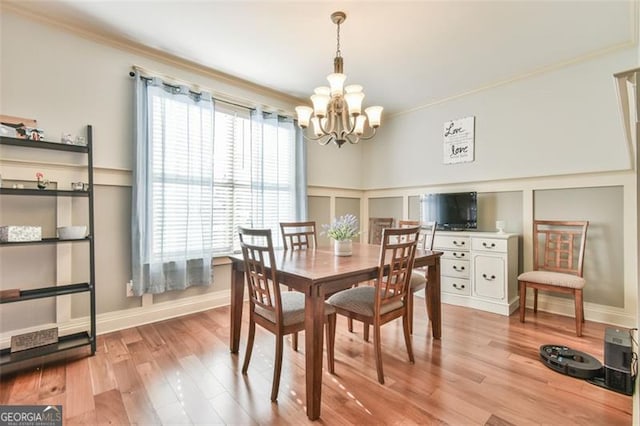 37 Wood Duck Pt, Jefferson, GA 30549 - dining room with a chandelier, a decorative wall, crown molding, light wood-style flooring, and wainscoting