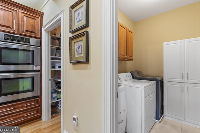 washroom featuring cabinet space and washing machine and dryer