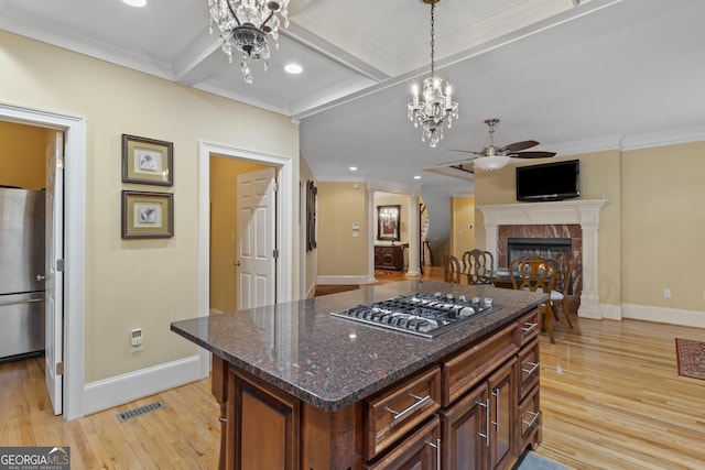 kitchen featuring visible vents, a tiled fireplace, appliances with stainless steel finishes, baseboards, and ceiling fan with notable chandelier
