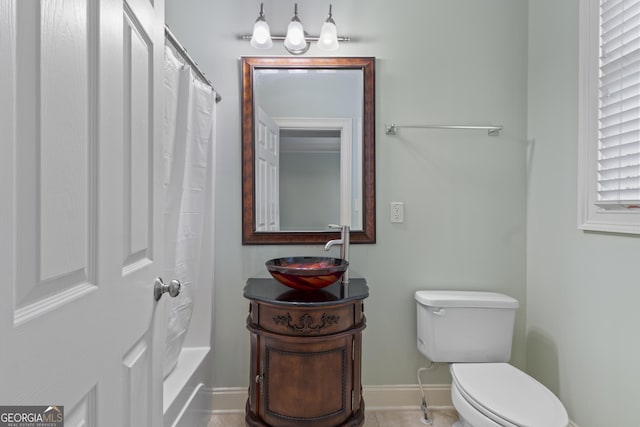 bathroom featuring baseboards, vanity, and toilet