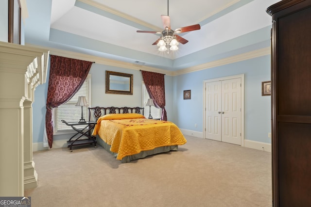 bedroom featuring crown molding, a raised ceiling, baseboards, and light carpet