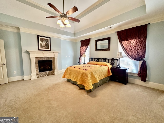 bedroom with visible vents, baseboards, a raised ceiling, ornamental molding, and carpet