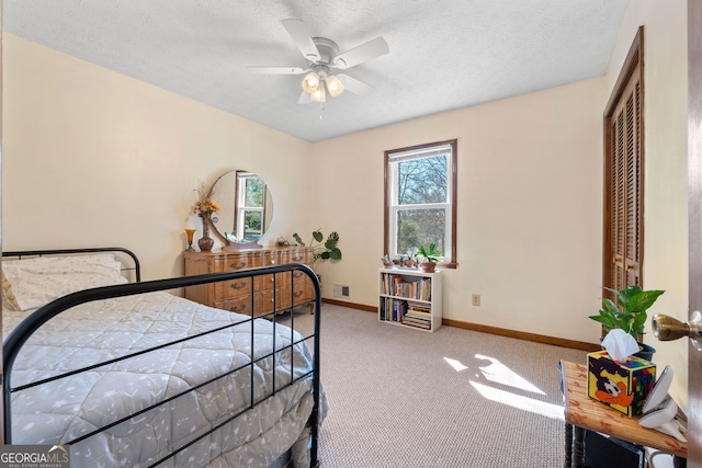 bedroom with a textured ceiling, baseboards, visible vents, and carpet