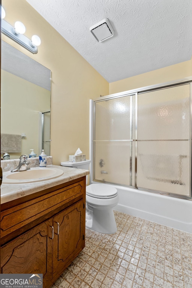 bathroom featuring a textured ceiling, vanity, tile patterned floors, toilet, and enclosed tub / shower combo