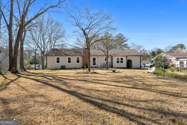 back of property with a lawn and central AC unit