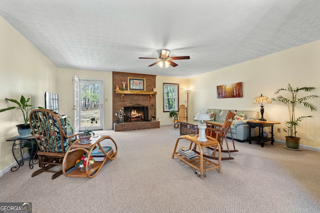 carpeted living room with baseboards, ceiling fan, a brick fireplace, and a textured ceiling