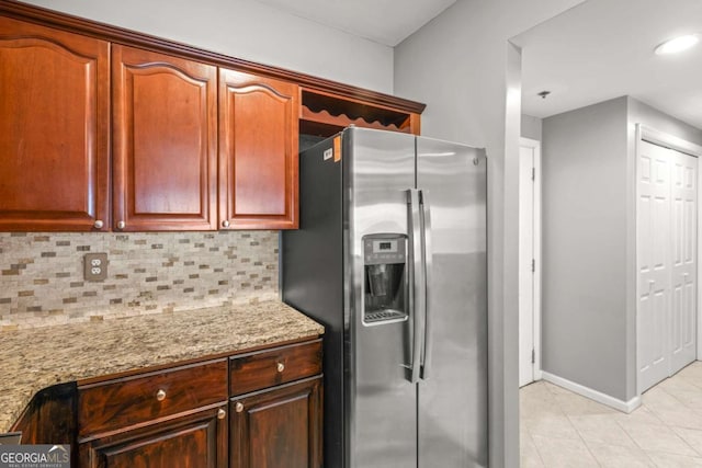 1502 River Green Dr NW Unit 1502, Atlanta, GA 30327 - kitchen featuring light stone countertops, stainless steel fridge, baseboards, light tile patterned floors, and tasteful backsplash