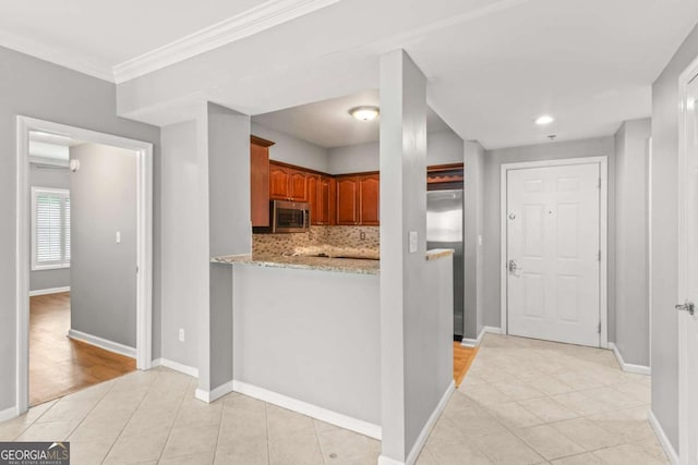 1502 River Green Dr NW Unit 1502, Atlanta, GA 30327 - kitchen with brown cabinetry, backsplash, appliances with stainless steel finishes, light tile patterned floors, and baseboards