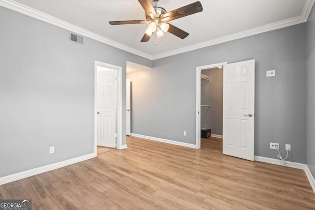1502 River Green Dr NW Unit 1502, Atlanta, GA 30327 - unfurnished bedroom with visible vents, crown molding, baseboards, a spacious closet, and light wood finished floors