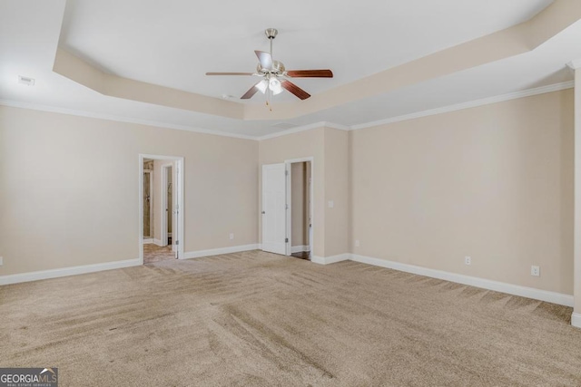 carpeted empty room featuring crown molding, a raised ceiling, ceiling fan, and baseboards