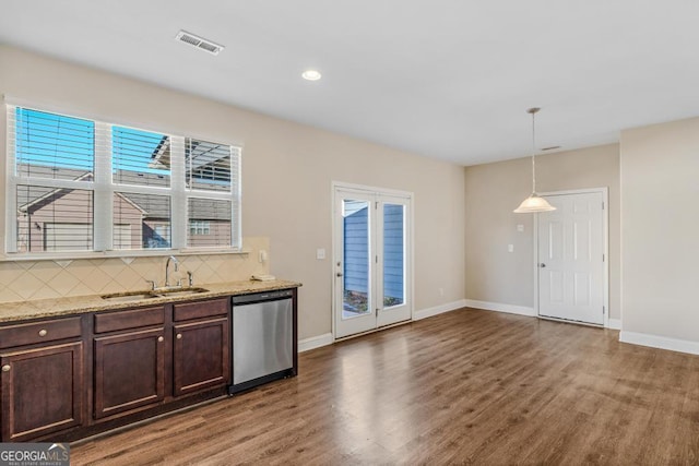 kitchen with stainless steel dishwasher, a sink, wood finished floors, and visible vents