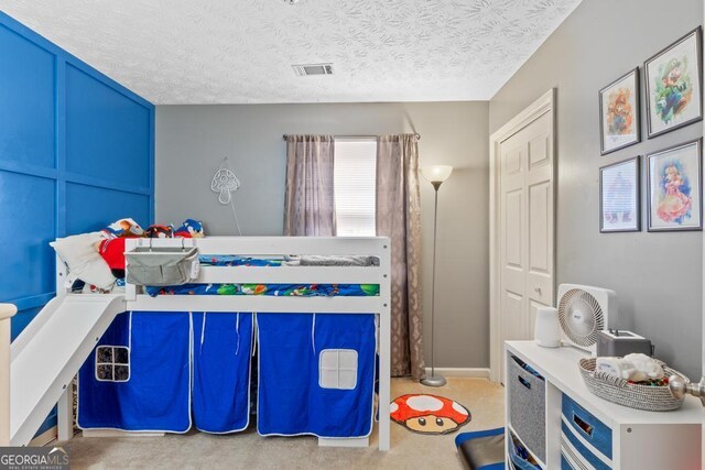 bedroom with a textured ceiling and visible vents