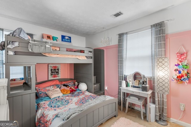 bedroom with visible vents, carpet flooring, a textured ceiling, and multiple windows
