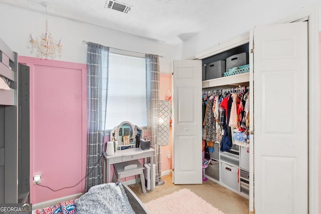 carpeted bedroom with a closet, visible vents, multiple windows, and a notable chandelier