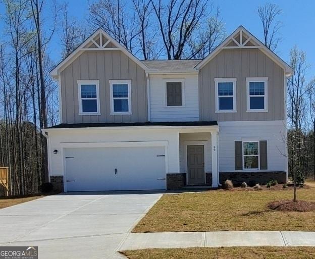 view of front of home with an attached garage, board and batten siding, driveway, and stone siding
