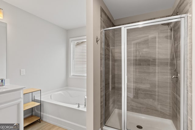 full bathroom featuring vanity, wood finished floors, a garden tub, and a shower stall