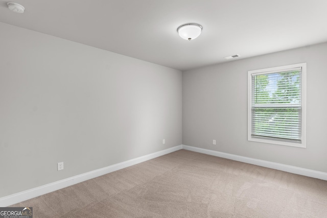 carpeted empty room with baseboards and visible vents